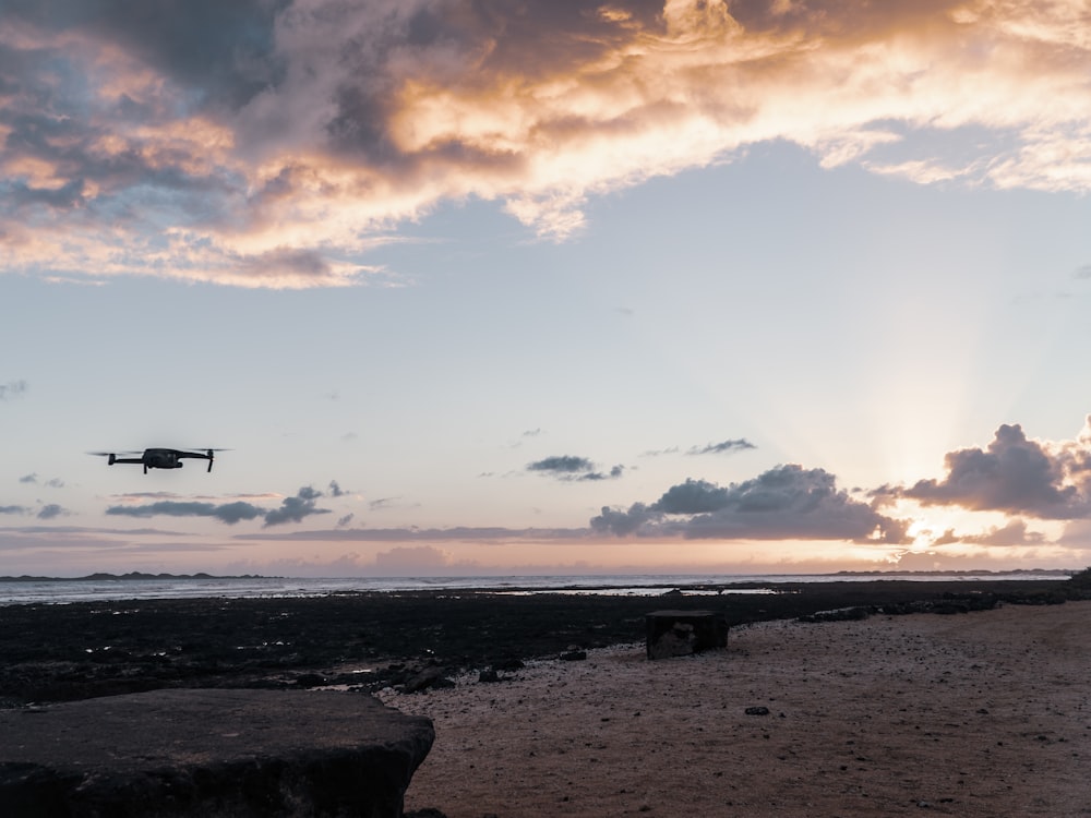 silhouette of person standing on seashore during daytime