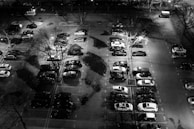 Night vision CCTV footage showing a clear view of a parking lot.