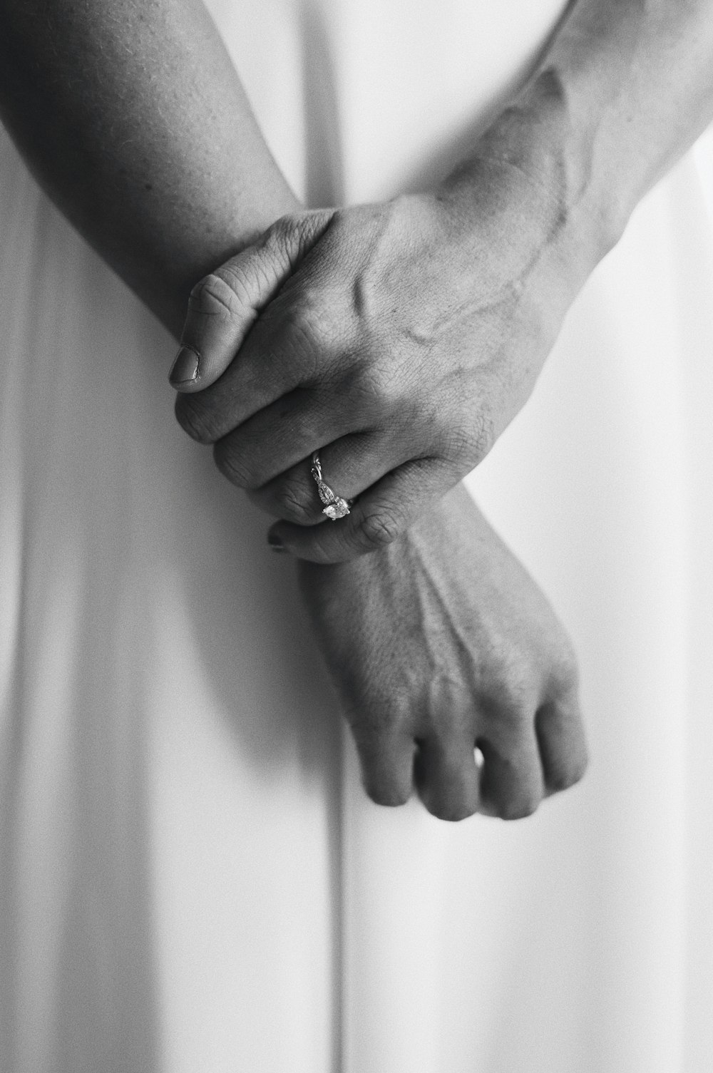 Foto en escala de grises de una pareja tomada de la mano
