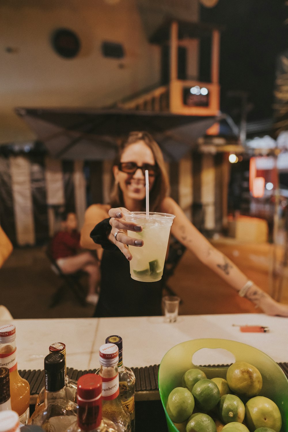 woman in black long sleeve shirt holding clear drinking glass