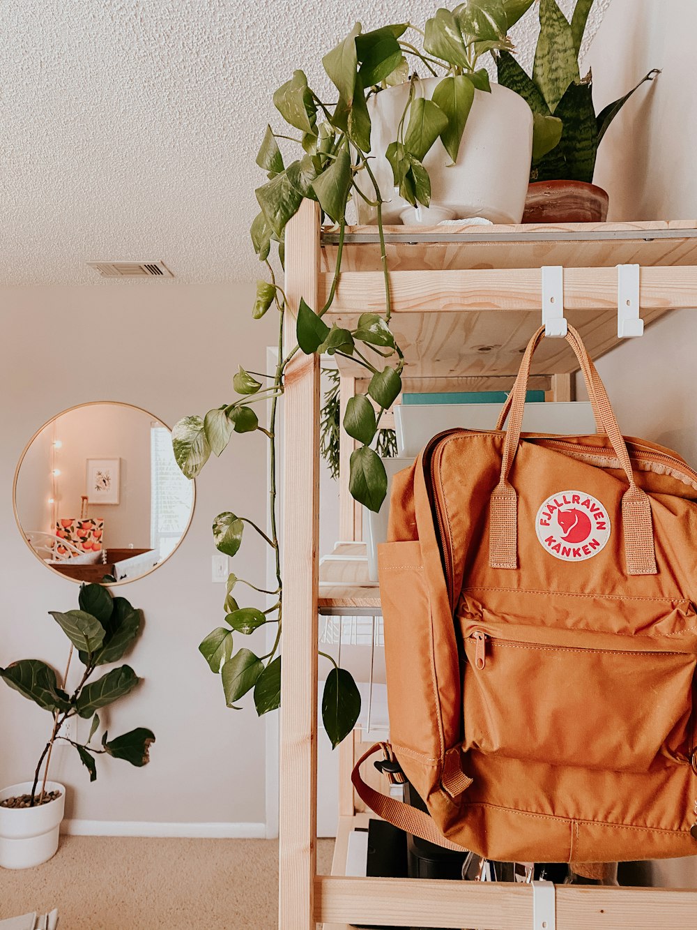 brown leather tote bag hanged on white wooden rack