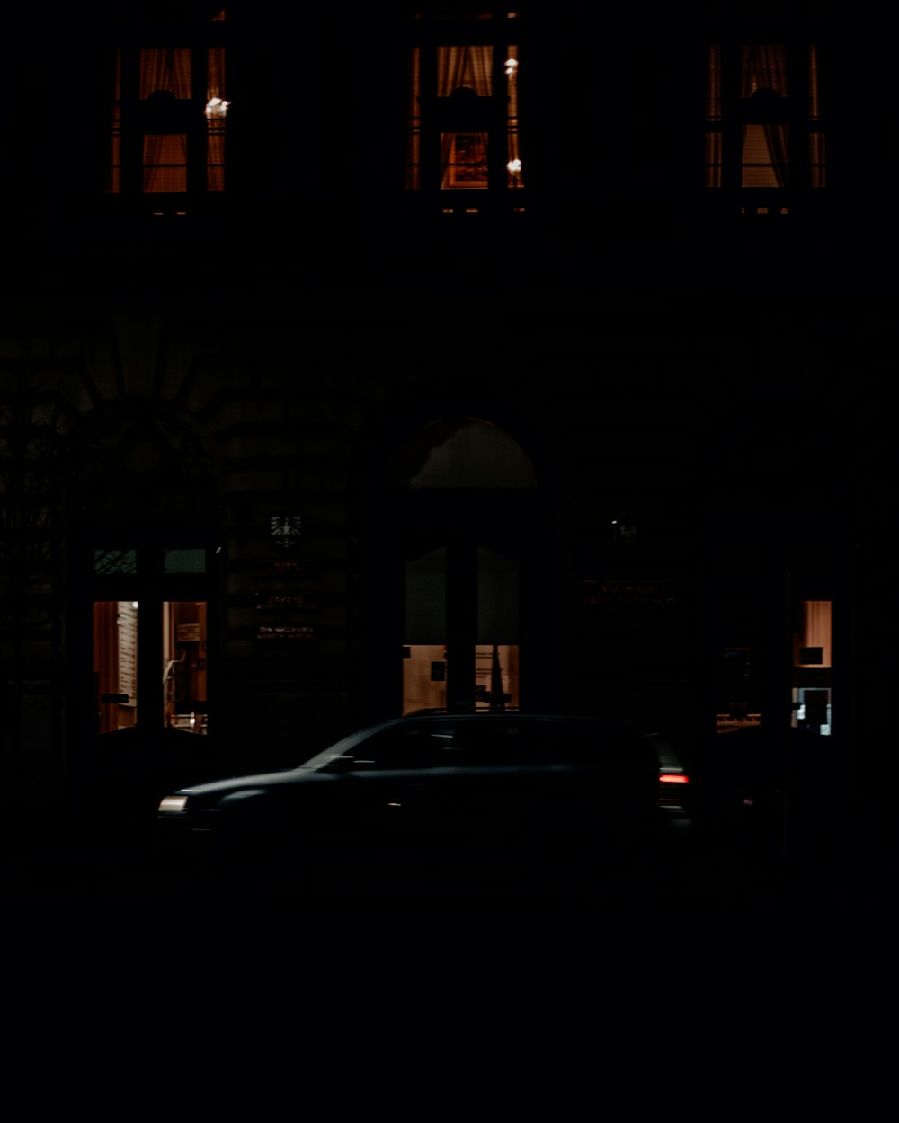 cars parked in front of brown building during night time