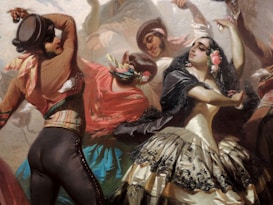 A lively scene depicting a group of dancers in traditional attire, engaging in an energetic performance. The dancers wear colorful clothing with intricate patterns, including floral accents and flowing skirts. Their expressions reflect joy and passion as they move in close proximity.