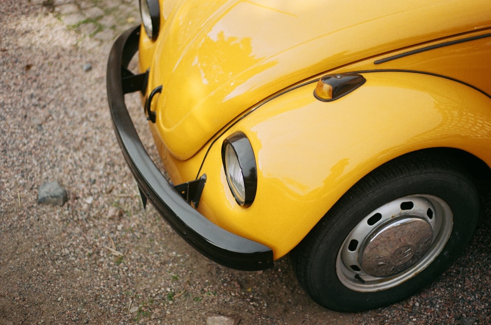 yellow volkswagen beetle on gray concrete pavement during daytime