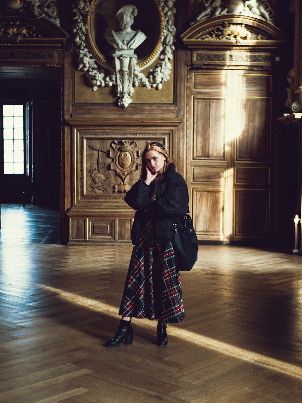 woman in black and red dress standing on brown wooden floor