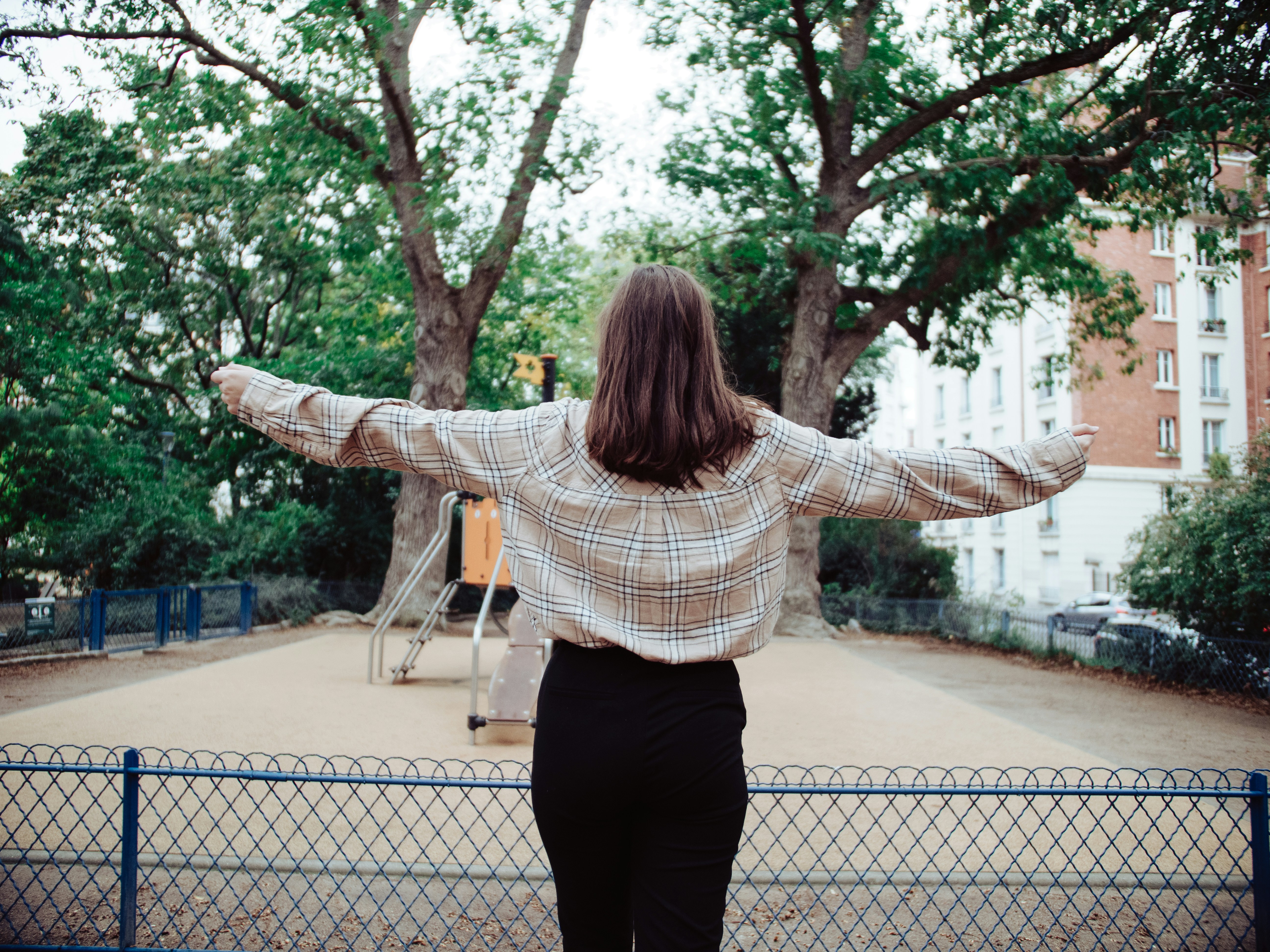 woman in white and black striped long sleeve shirt and black pants standing on gray concrete
