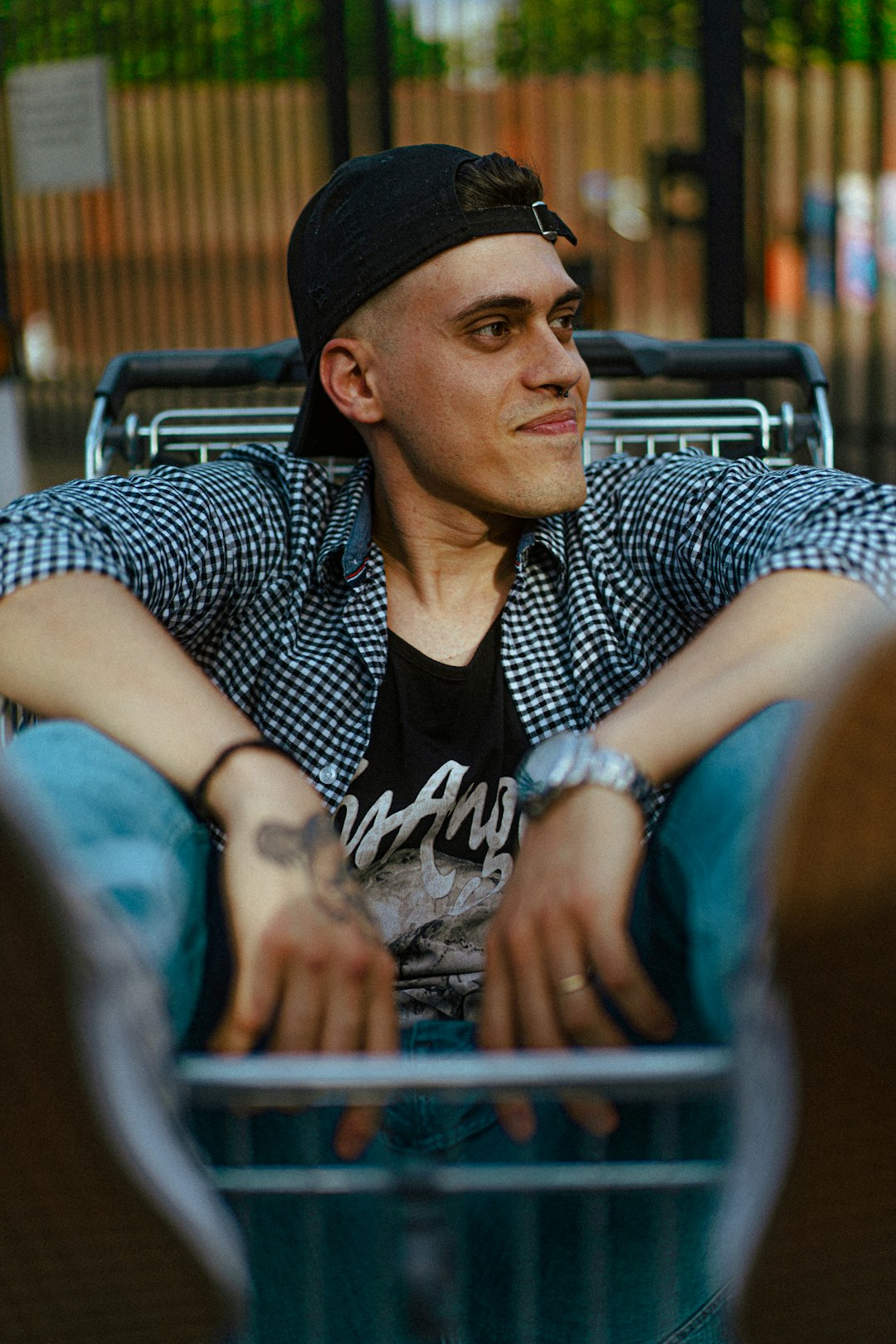 man in black and white polka dot shirt sitting on brown wooden chair