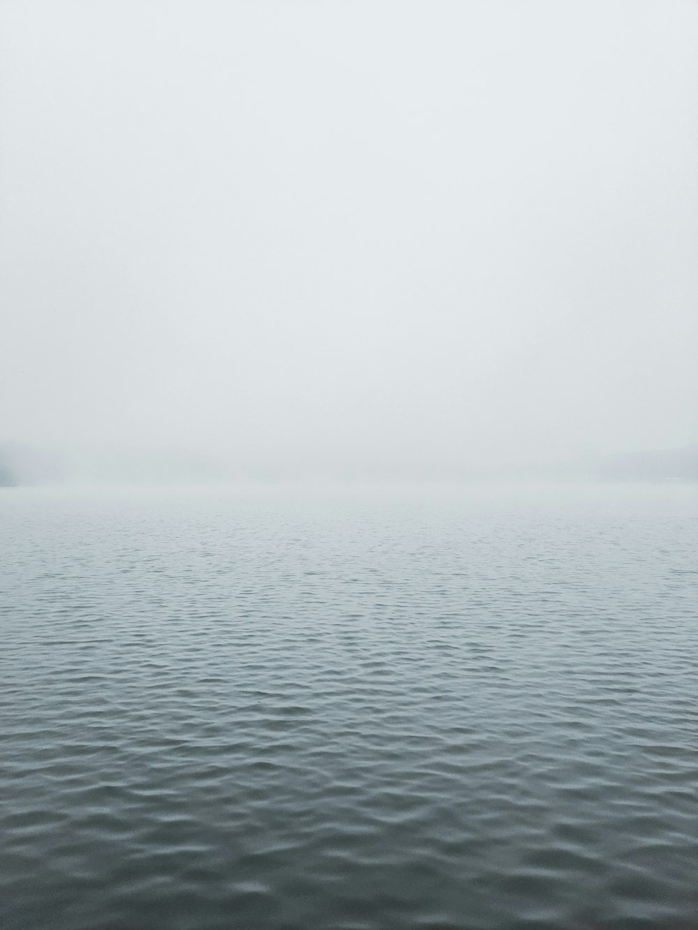 body of water under white sky during daytime