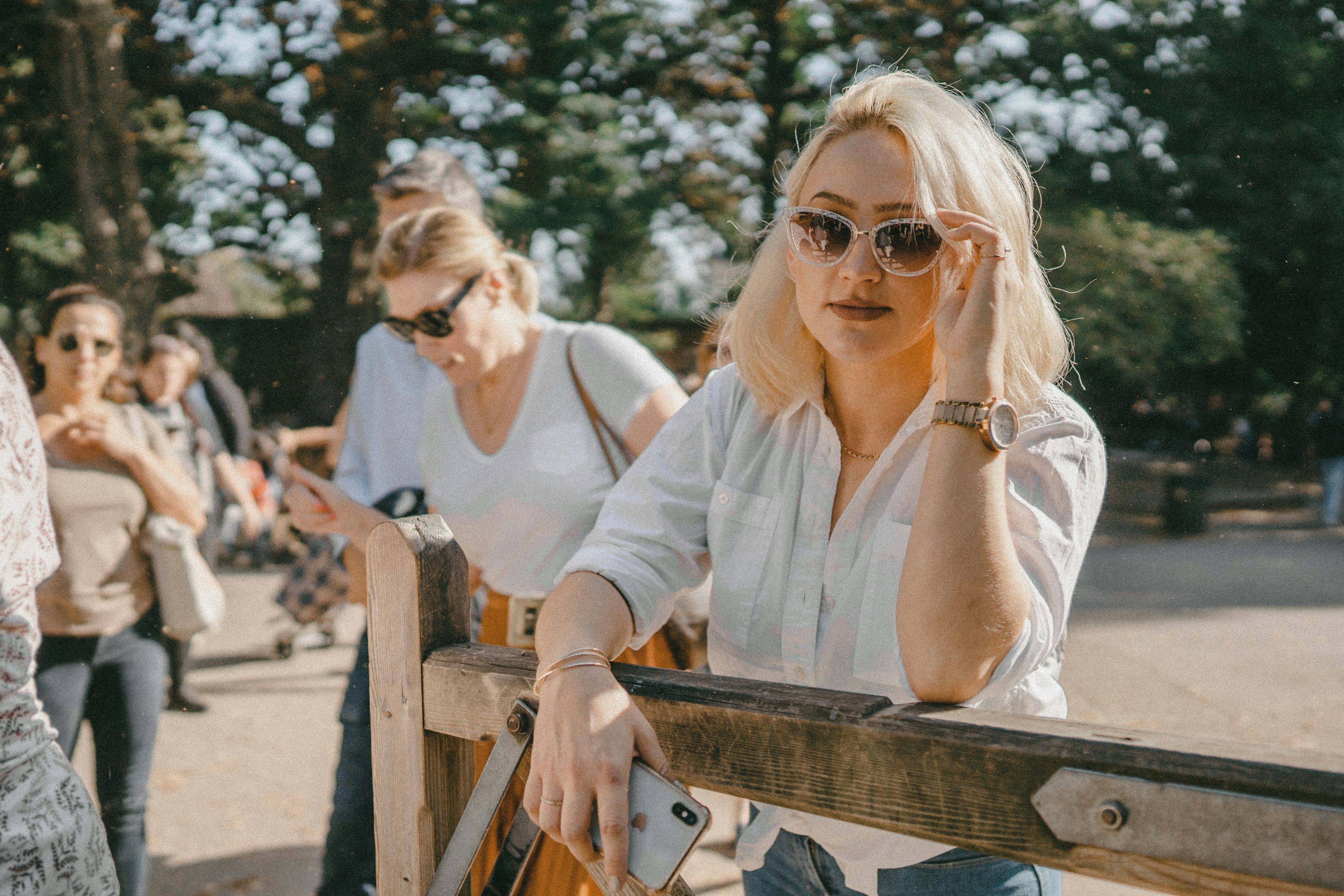woman in white long sleeve shirt wearing sunglasses sitting on bench