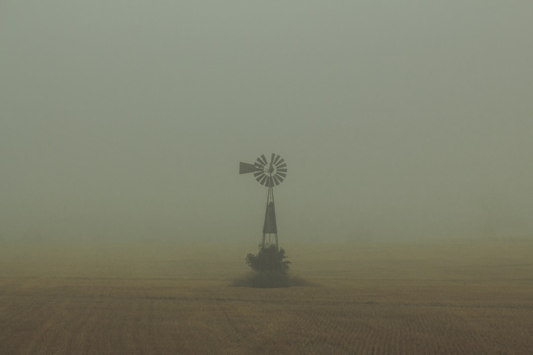 black and white windmill on brown field