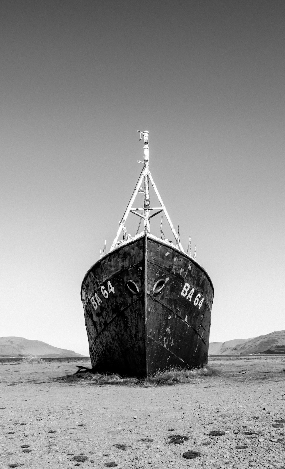 grayscale photo of a ship on a beach