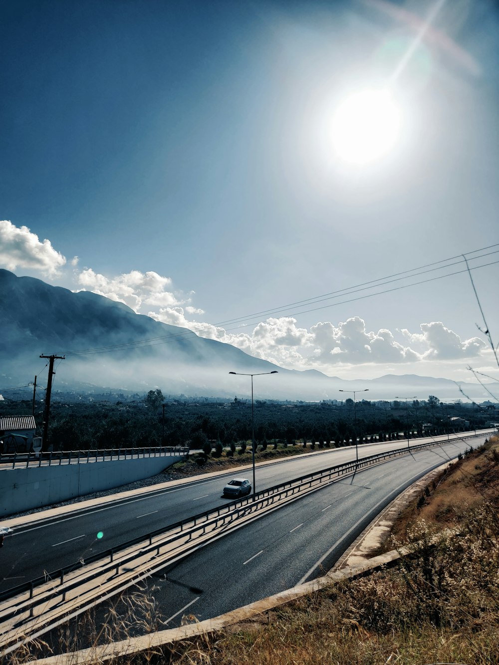 gray concrete road under blue sky during daytime