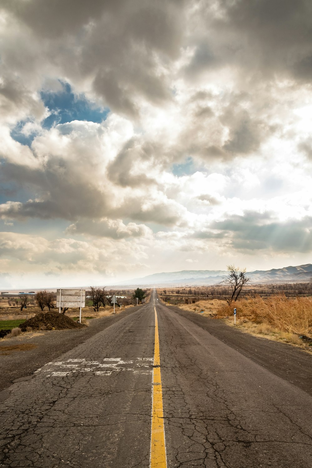 gray asphalt road under cloudy sky during daytime