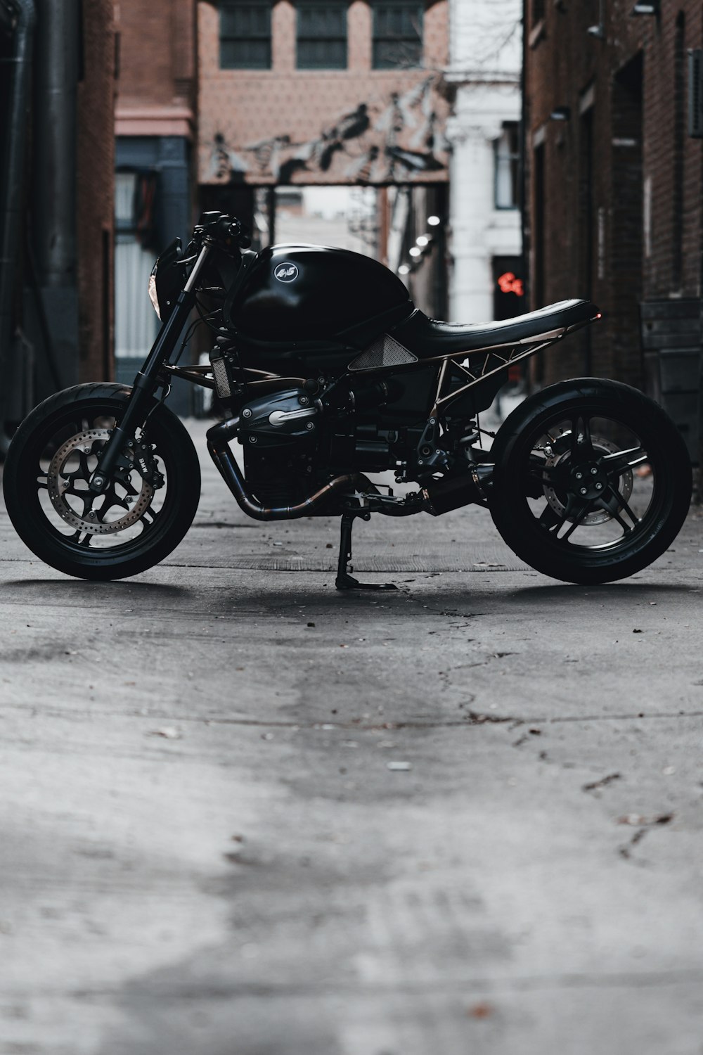 black motorcycle parked beside brown wooden door