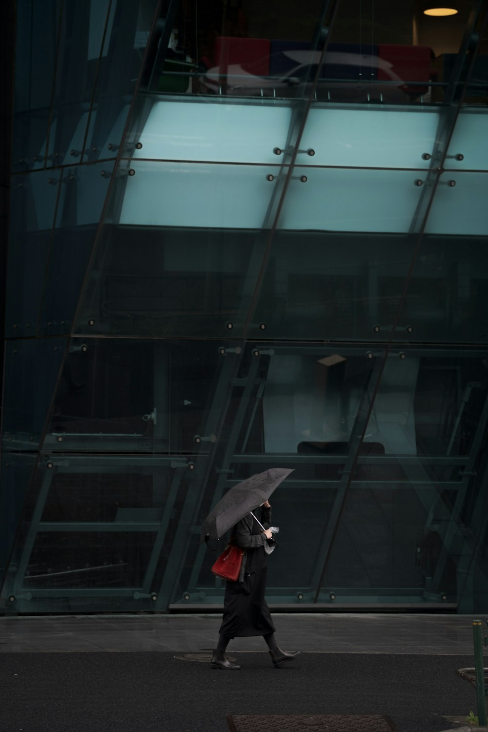 person in black jacket and black pants holding umbrella