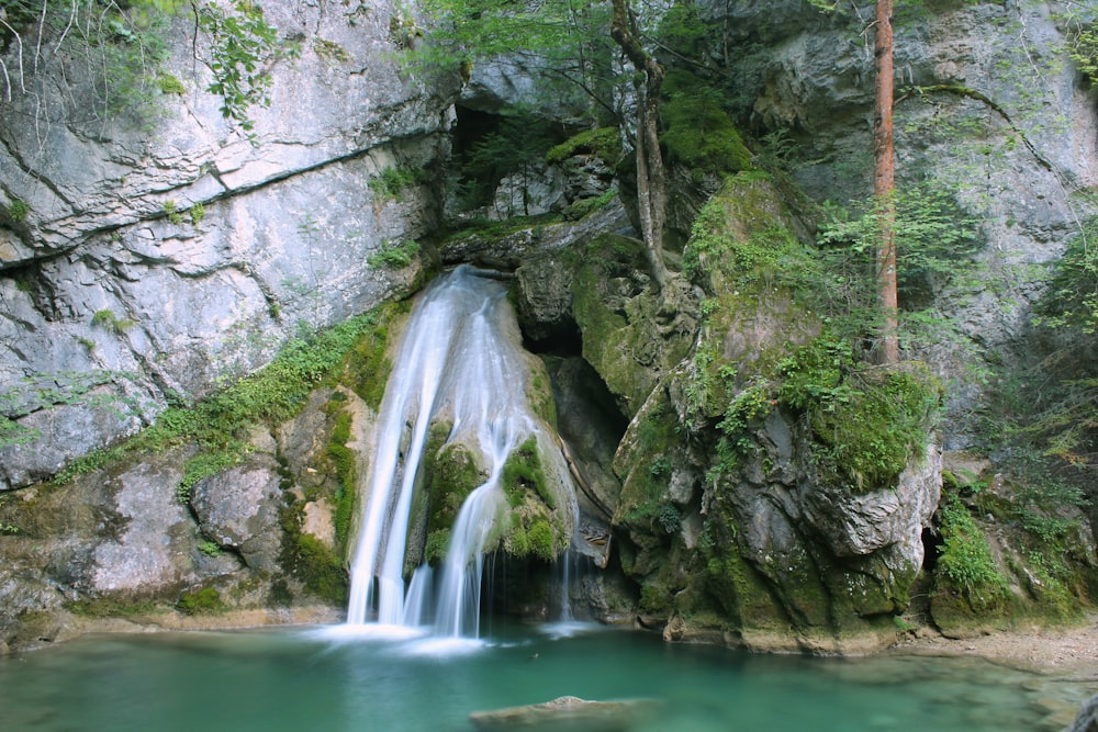 chutes d’eau entre les montagnes rocheuses grises pendant la journée