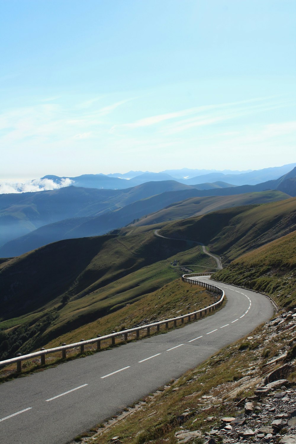 昼間の緑の山々の間の灰色のコンクリート道路