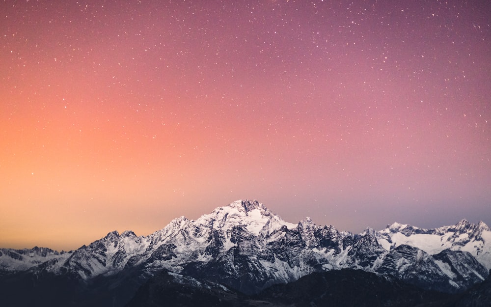 montagne enneigée sous ciel bleu pendant la journée