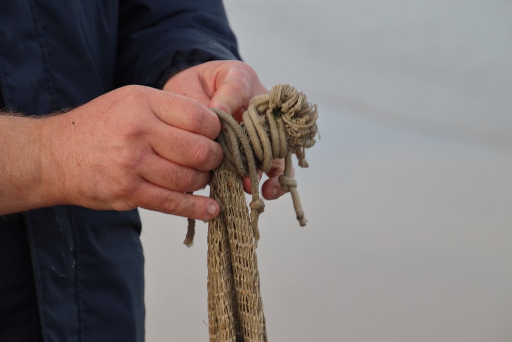 person holding brown rope during daytime