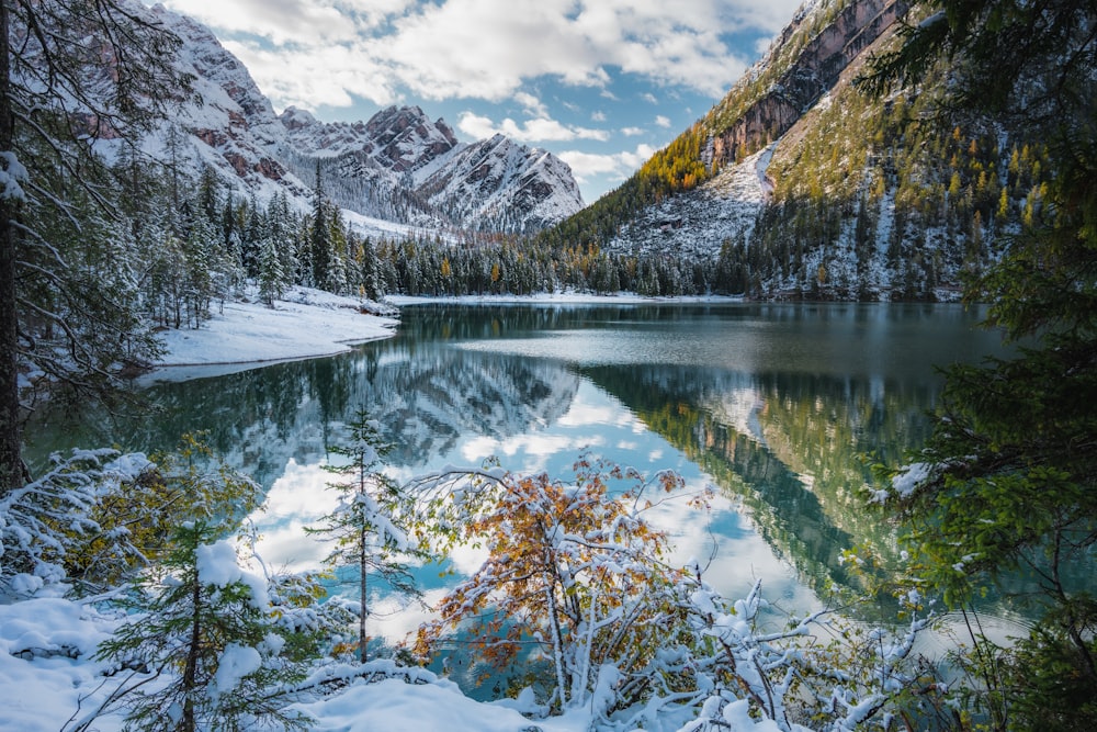 snow covered mountain near lake during daytime