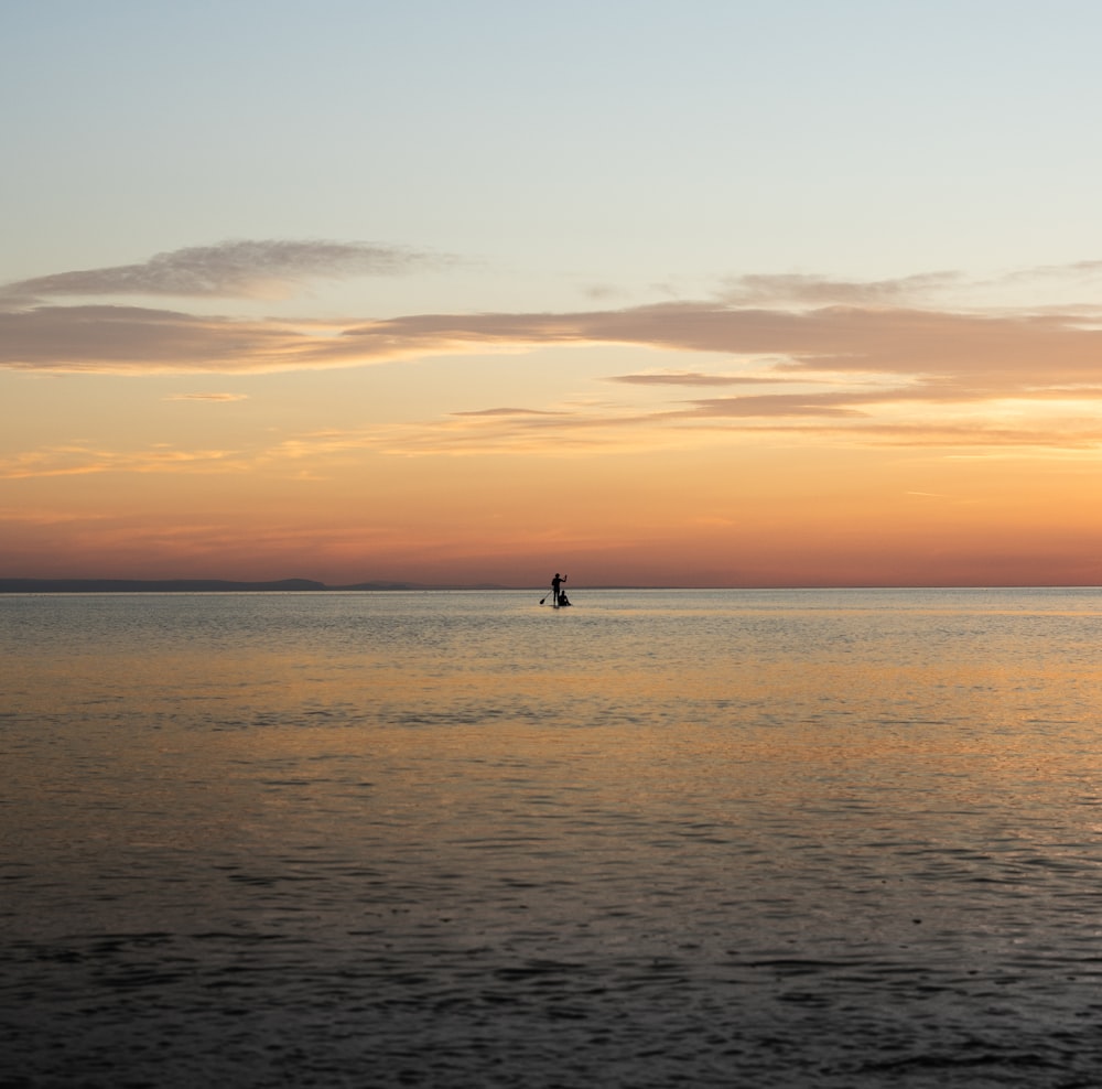 person standing on beach during sunset