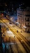 cars on road in between buildings during night time