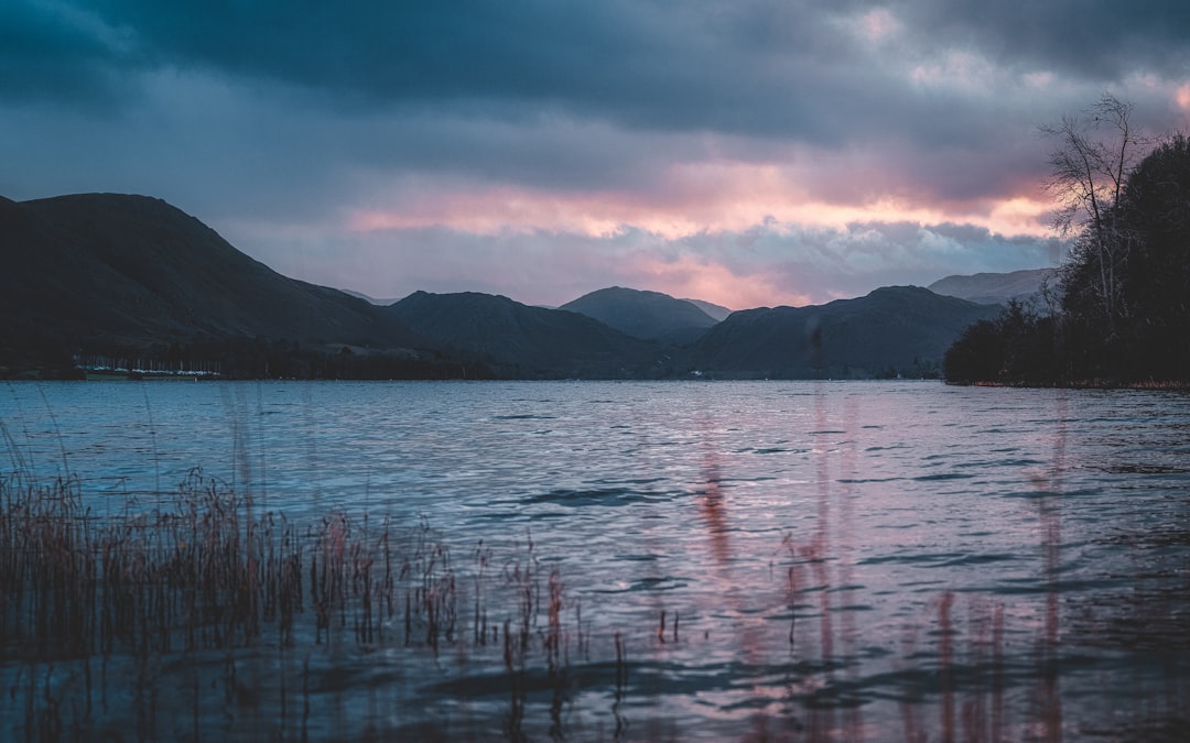 body of water near mountain during daytime