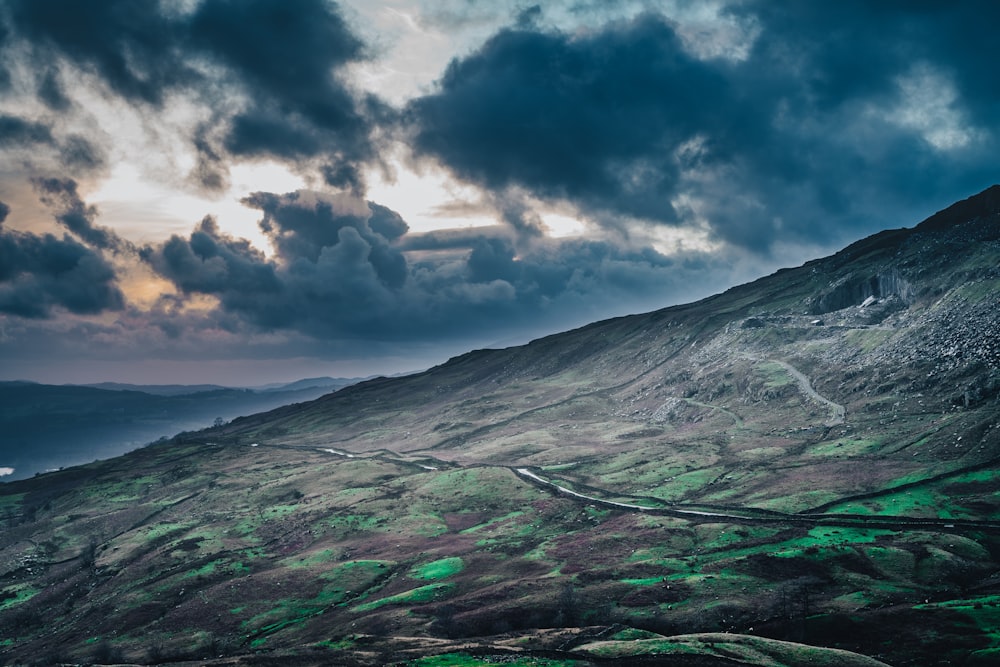 green and gray mountain under cloudy sky during daytime