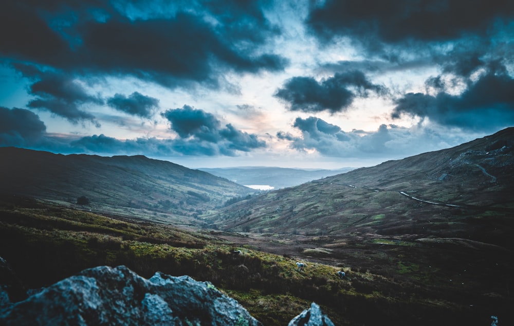 green and brown mountains under white clouds and blue sky during daytime