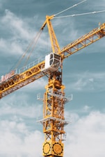 yellow and black crane under cloudy sky during daytime