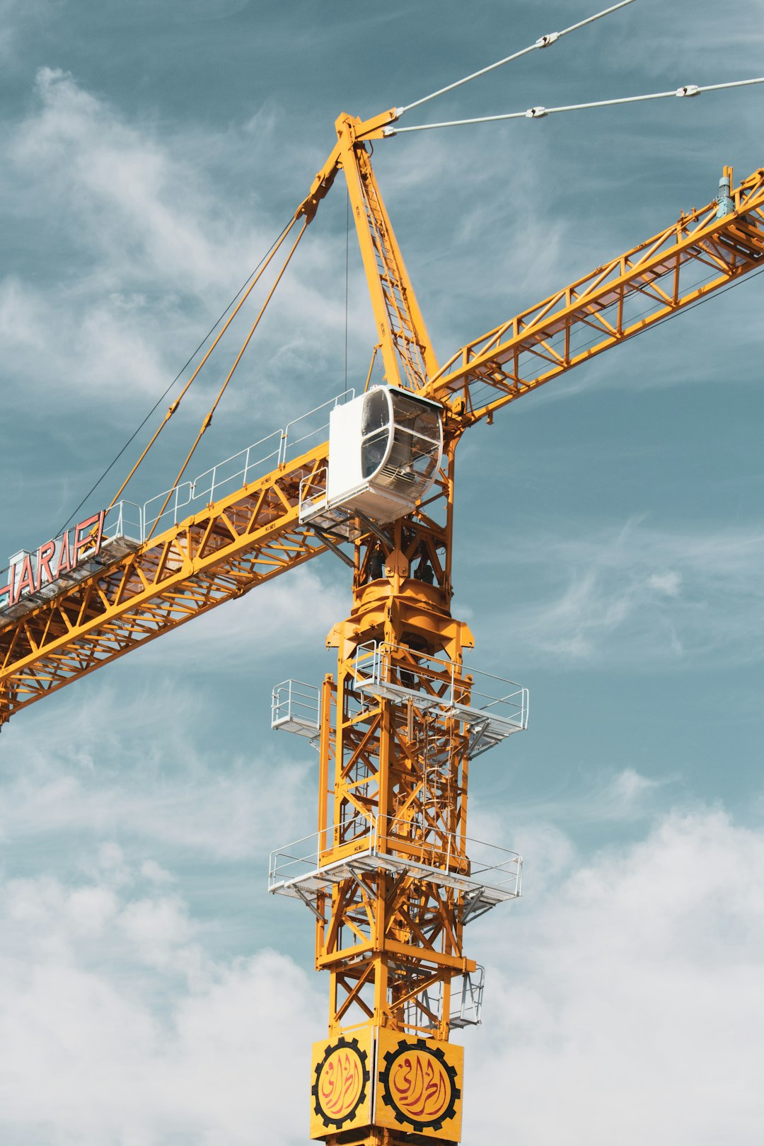 yellow and black crane under cloudy sky during daytime