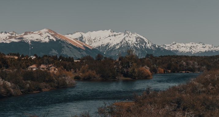 A serene landscape of Salzburg with mountains and a calm river.