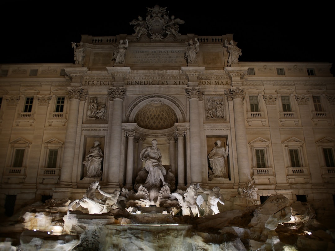 people sitting on rock near building, Closer view on the Trevi fountain.