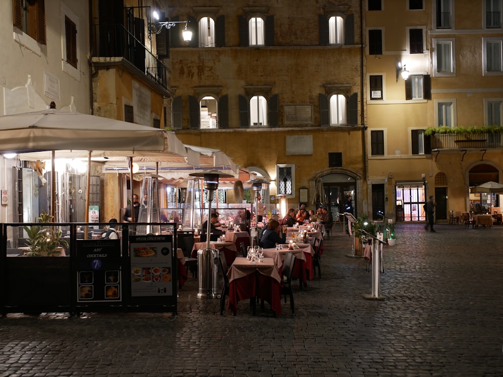 people sitting on chair near table and building during daytime