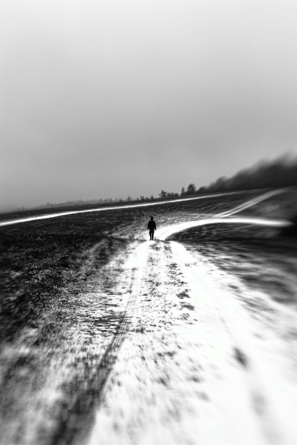 grayscale photo of person walking on beach