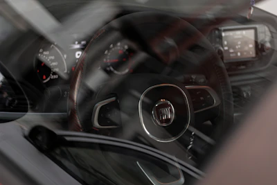 Original Fiat foot mats, both rubber winter and velour summer sets, neatly arranged inside a Fiat 500c.