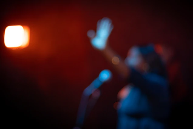 Cinematic portrait of Rodrigo Bareja with dramatic side lighting and a blurred microphone in the foreground.