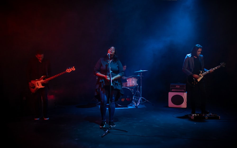 man in red dress shirt playing guitar