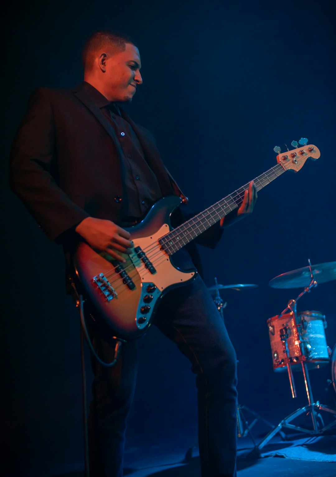man in black coat playing electric guitar