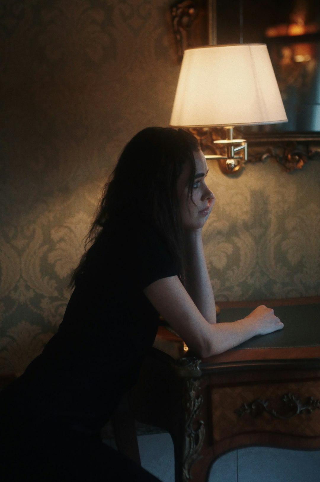 woman in black shirt wearing eyeglasses sitting by the table