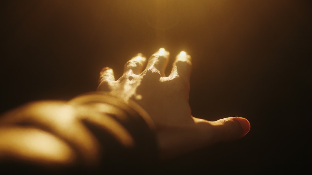 person holding lighted candle in dark room