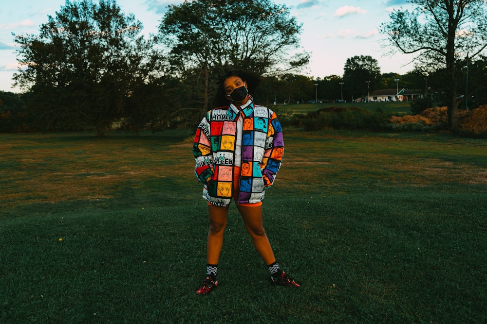 woman in blue white and red plaid shirt standing on green grass field during daytime