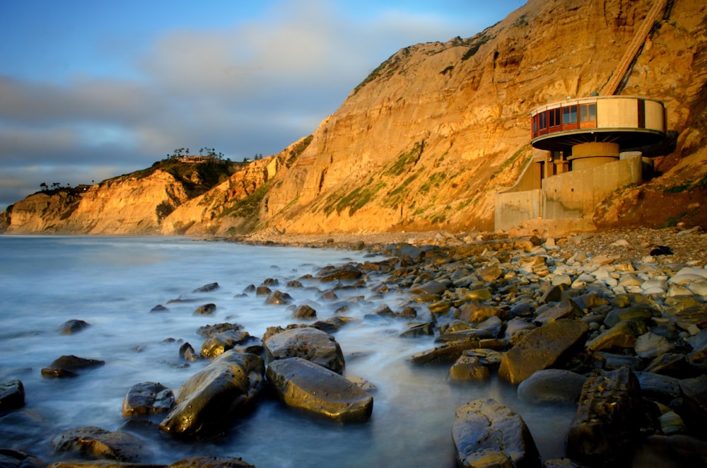 brown rock formation beside body of water during daytime