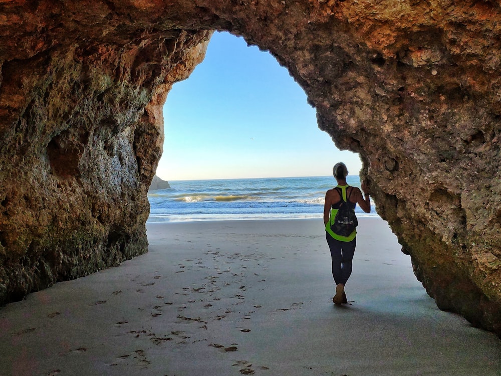 uomo in giacca nera e pantaloni neri in piedi sulla spiaggia durante il giorno