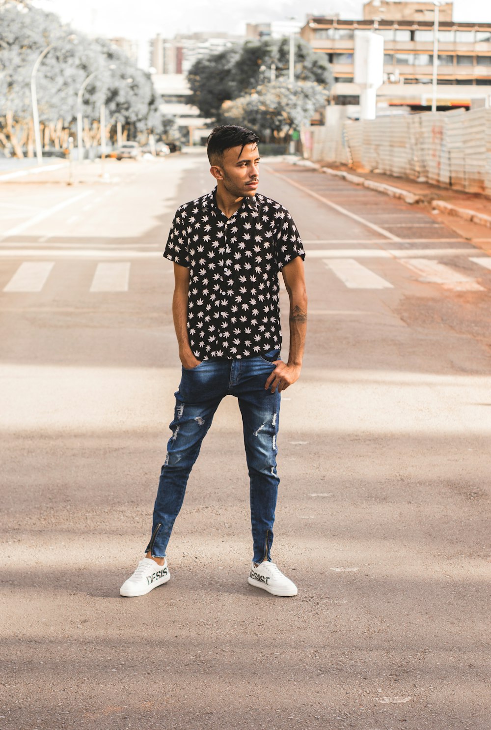 Man in black and white polka dot shirt and blue denim jeans