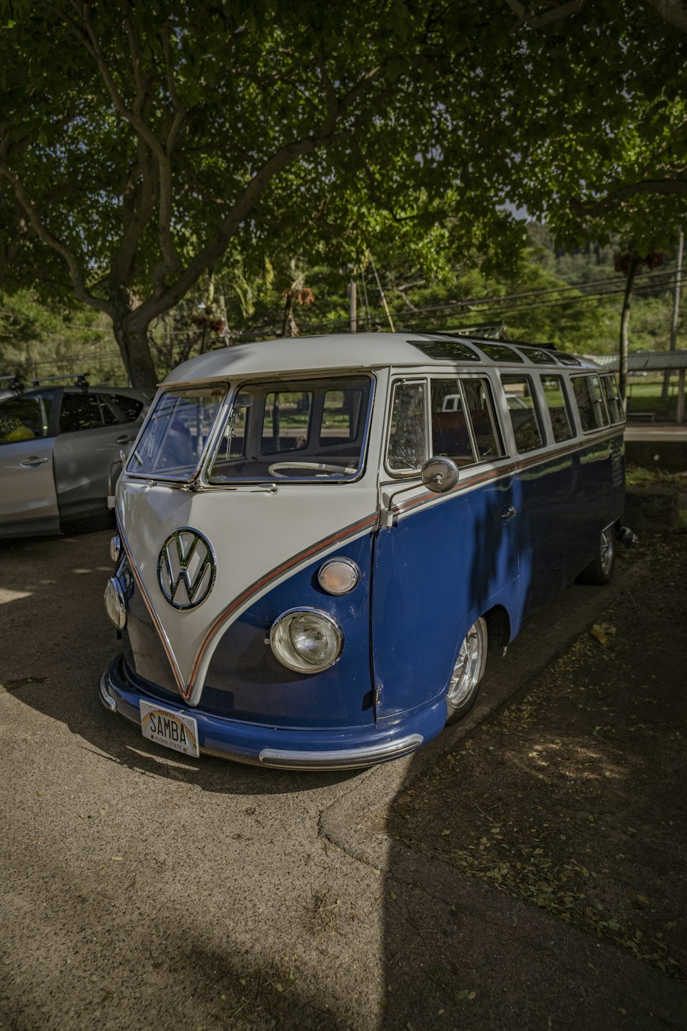 blue and white volkswagen t-2 parked on the side of the road
