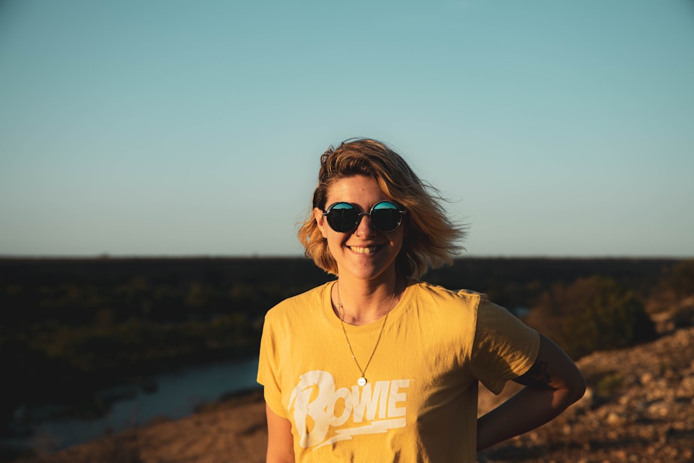 woman in yellow and black crew neck t-shirt wearing black sunglasses