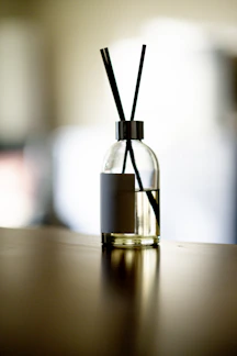Close-up of elegant reed diffusers with natural wooden sticks in soft neutral tones.