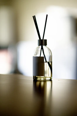 Handcrafted essential oil diffuser blends in glass bottles glowing softly against a bright blue river backdrop.