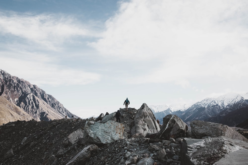 person standing on rocky mountain during daytime